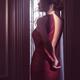 Sensual boudoir portrait a woman in red leather dress pulling down zip... (thumbnail)