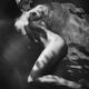 Beautiful nude woman lying in dark water with water droplets on her we... (thumbnail)