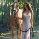 Beautiful woman inelegant silvery silk dress walking with a horse alon... (thumbnail)
