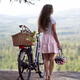 Girl with an electric bike and a pink bicycle helmet enjoying the natu... (thumbnail)