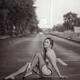 Half-nude woman in fishnet stockings sitting on the street asphalt. Bl... (thumbnail)