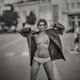 Young woman taking off her clothes standing half-naked on a city stree... (thumbnail)