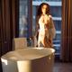Beautiful sexy woman in white sheer lace night gown standing by a bath... (thumbnail)