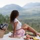 Girl sitting on a blanket with fruits and a book enjoying a little pic... (thumbnail)