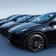 Black Tesla Model Y and Tesla 3 electric cars in a row on blue backgro... (thumbnail)