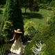 Young lady in summer dress and sun hat running down the staircase of a... (thumbnail)