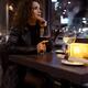 Portrait of an attractive woman in black leather coat sitting alone at... (thumbnail)