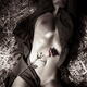 Sexy half-naked woman lying stretched out on straw in an open dress ov... (thumbnail)