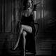 Elegant lady in black dress revealing her sexy legs holding long cigar... (thumbnail)