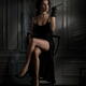 Elegant lady in black dress revealing her sexy legs sitting holding lo... (thumbnail)