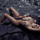 Beautiful nude woman making love to an octopus lying in dark sea water... (thumbnail)
