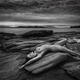 Beautiful nude young woman lying naked stretched on ocean shore rock i... (thumbnail)