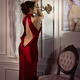 Beautiful classy elegant lady in red evening gown with open back leani... (thumbnail)