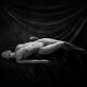 Fine art nude black and white portrait of woman lying in graceful pose... (thumbnail)