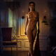 Beautiful lady with seductive enticing gaze walking naked across a dim... (thumbnail)