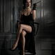 Elegant woman in black silk dress sitting in dark room with her sexy l... (thumbnail)