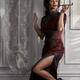 Elegant lady in Shanghai-style Cheongsam dress leaning against wall sm... (thumbnail)