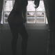 Sexy silhouette of a woman in lingerie putting on black stockings in a... (thumbnail)