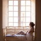 Beautiful lady in sheer white lace nightgown sitting on vintage sofa b... (thumbnail)