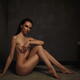 Beautiful nude woman sitting in a sensual pose in a dark bathroom... (thumbnail)