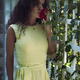 Beautiful woman with an expressive deep gaze smelling a red rose in a... (thumbnail)