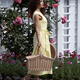 Beautiful lady in yellow summer dress walking with a basket by a garde... (thumbnail)
