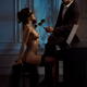 Gentleman caressing with a red rose a gorgeous woman sitting at a pian... (thumbnail)