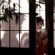 Beautiful caucasian lady, Japanese geisha with hand fan behind shoji s... (thumbnail)