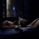 Woman lying on bed with a large boa constrictor snake slithering over... (thumbnail)