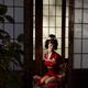 Beautiful caucasian lady, Japanese geisha in red kimono sitting tied u... (thumbnail)