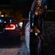 Provocatively dressed seductive woman in black leather coat smoking ci... (thumbnail)