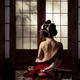 Beautiful geisha sitting in undone red kimono revealing her bare back... (thumbnail)