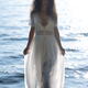 Gorgeous goddess-like woman in sheer white dress walking out of sea wa... (thumbnail)