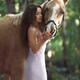 Beautiful woman rider in elegant dress caressing a horse in nature wit... (thumbnail)