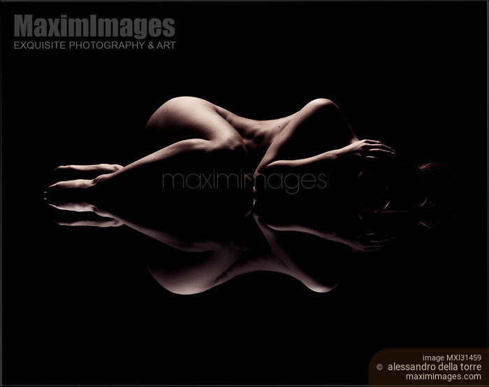 Stock photo of Abstract art nude figure of a woman lying curled up with a reflection Buy commercial use license at MaximImages