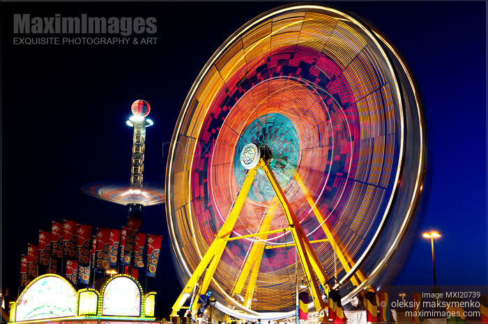 Stock photo of Amusement Rides Spinning Observation Wheel at Night Buy commercial use license at MaximImages