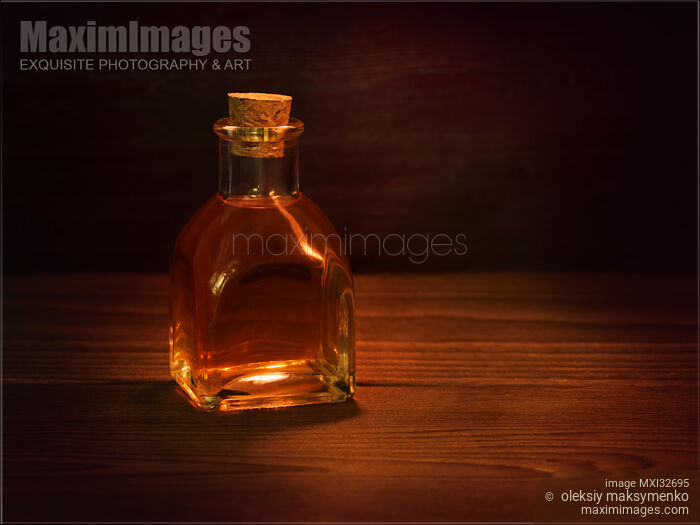 Antique glass bottle with a cork and amber liquid of extract or elixir Still life Stock photo of Antique glass bottle with a cork and amber liquid of extract or elixir Still life Buy commercial use license at MaximImages