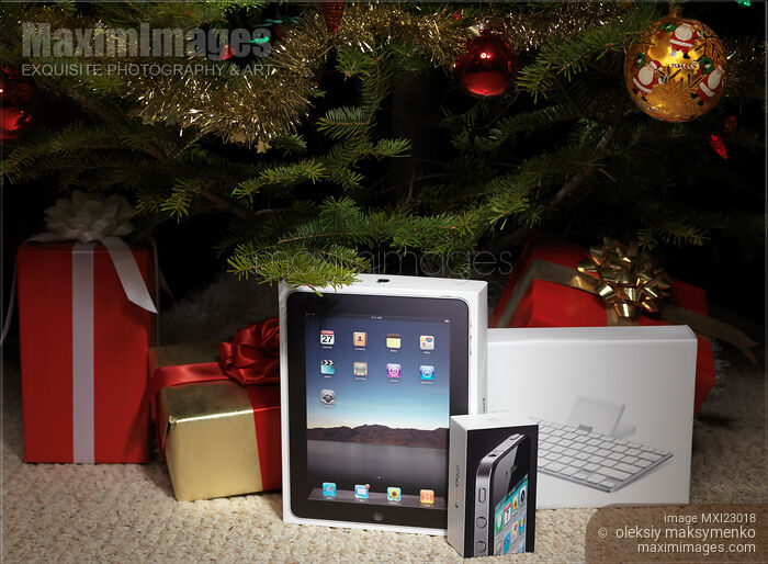 Stock photo of Apple iPad and iPhone Amongst Christmas Presents Buy commercial use license at MaximImages