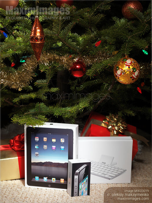 Stock photo of Apple iPad and iPhone Amongst Christmas Presents Buy commercial use license at MaximImages