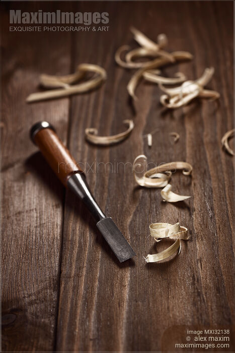 Stock photo of Artistic carpentry still life of a chisel and wood shavings on a table Buy commercial use license at MaximImages