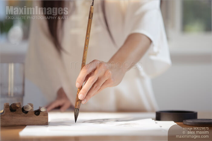 Artistic closeup of woman sumi-e artist hand with brush painting on rice paper Stock photo of Artistic closeup of woman sumi-e artist hand with brush painting on rice paper Buy commercial use license at MaximImages