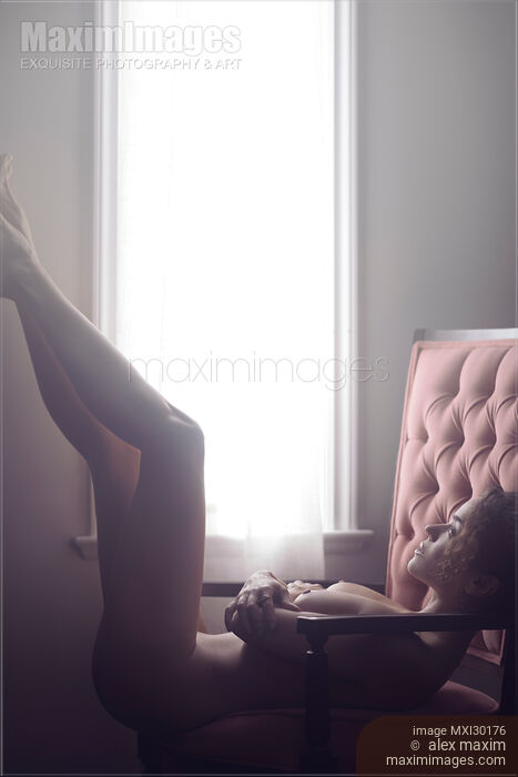 Artistic nude portrait of beautiful woman lying naked in armchair with her legs raised Stock photo of Artistic nude portrait of beautiful woman lying naked in armchair with her legs raised Buy commercial use license at MaximImages