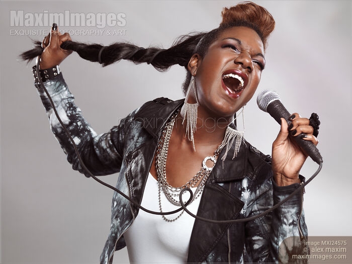 Stock photo of Artistic photo of woman singing in microphone Buy commercial use license at MaximImages