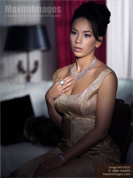 Artistic portrait of young woman sitting in dark bedroom Stock photo of Artistic portrait of young woman sitting in dark bedroom Buy commercial use license at MaximImages