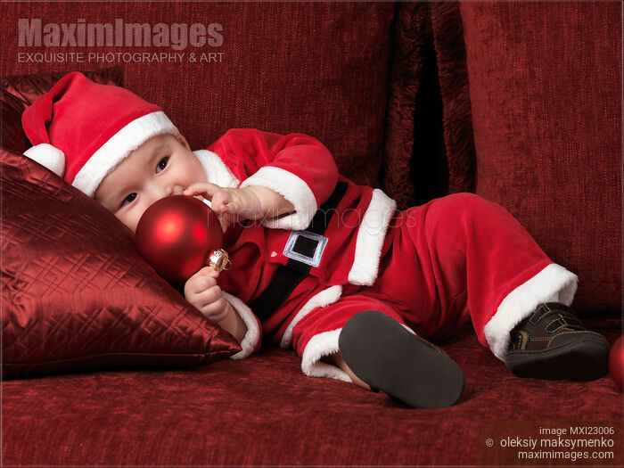 Baby Boy in Santas Costume with a Christmas Bauble Stock photo of Baby Boy in Santas Costume with a Christmas Bauble Buy commercial use license at MaximImages