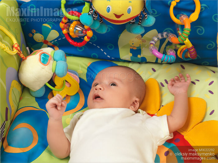Stock photo of Baby Boy Lying on a Play Mat Buy commercial use license at MaximImages