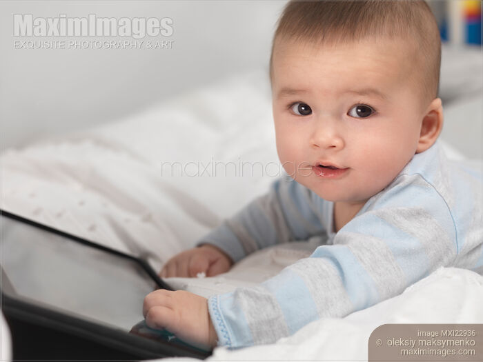 Stock photo of Baby Boy Playing with Tablet Computer Buy commercial use license at MaximImages