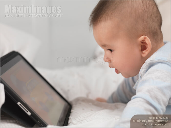 Stock photo of Baby Boy Watching at iPad Screen Buy commercial use license at MaximImages