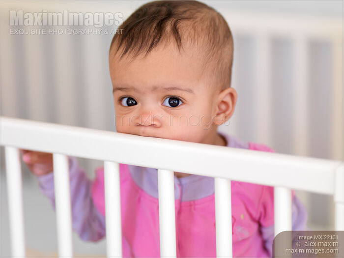 Stock photo of Baby Girl in a Crib Buy commercial use license at MaximImages