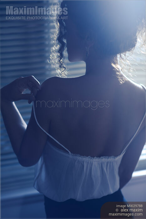 Back of sexy woman undressing by the window taking her night shirt off Stock photo of Back of sexy woman undressing by the window taking her night shirt off Buy commercial use license at MaximImages